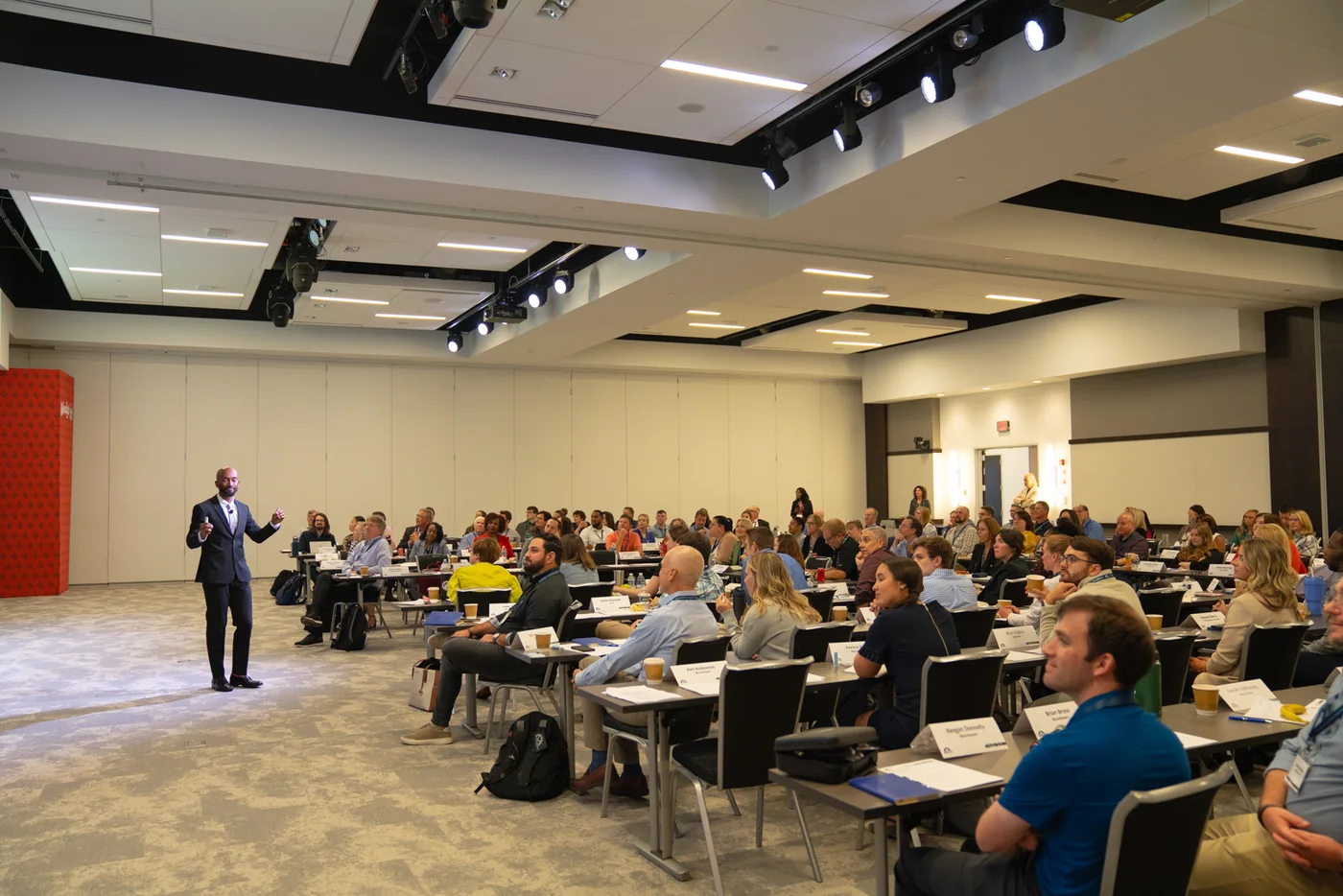 Emmanuel Aouad presenting in a large room.